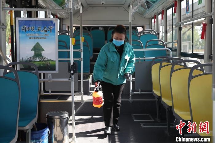 工作人員正在對(duì)公交車進(jìn)行消殺?！∮诰?攝