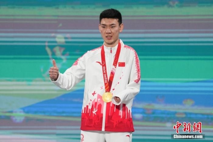 3月6日，梁景怡在延慶頒獎廣場領(lǐng)獎臺上豎起大拇指。當日，在國家高山滑雪中心舉行的北京2022年冬殘奧會殘奧高山滑雪男子超級大回轉(zhuǎn)—站姿決賽中，中國選手梁景怡奪得冠軍。 <a target='_blank' href='/'>中新社</a>記者 楊華峰 攝