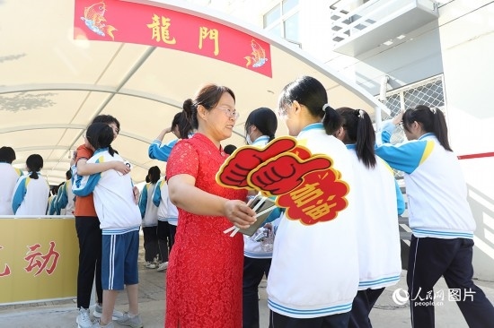 6月7日一早，雄安新區(qū)安新中學(xué)老師在給同學(xué)們加油鼓勁兒。人民網(wǎng) 李兆民攝