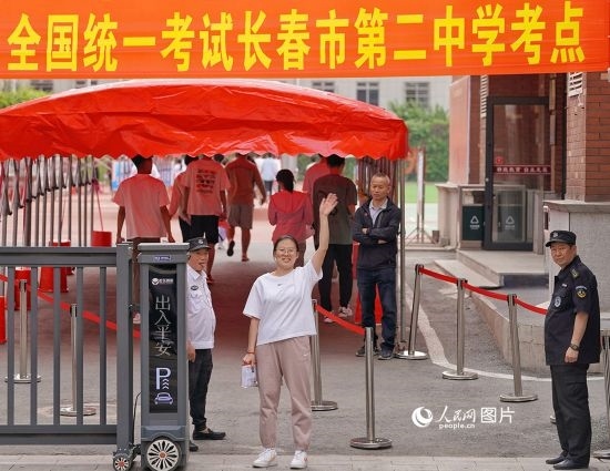 6月7日，在長春市第二中學(xué)考點(diǎn)，一名考生信心滿滿進(jìn)入考場，并與家長揮手致意。人民網(wǎng)記者 李洋攝
