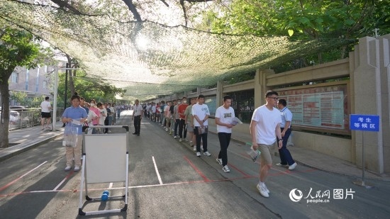 6月7日，烏魯木齊市第七十中學(xué)門口，考生們有序進(jìn)入考場。人民網(wǎng) 李欣洋攝