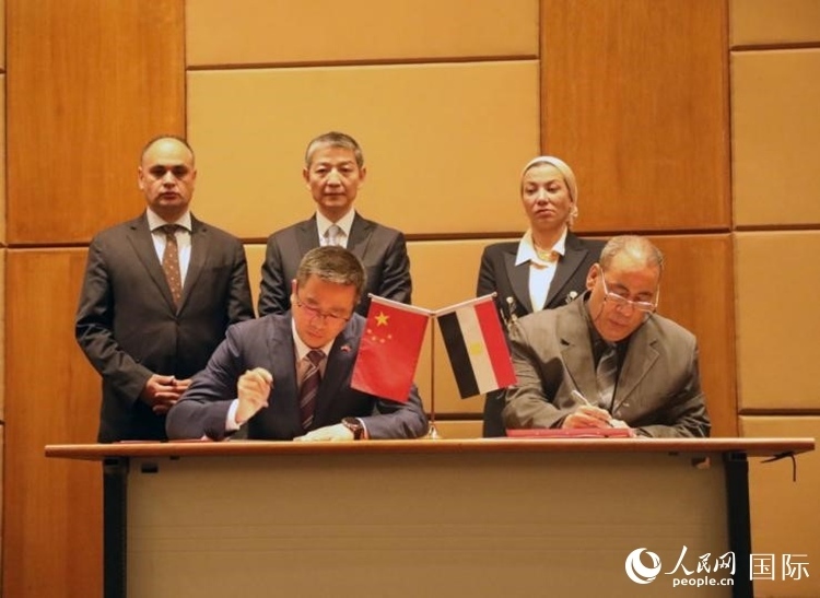 中國(guó)駐埃及使館公使張朝陽(yáng)與埃環(huán)境事務(wù)署工程和項(xiàng)目管理局局長(zhǎng)阿卜杜勒阿齊茲簽署交接證書。沈小曉攝