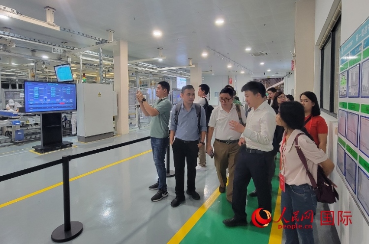 廣汽埃安工作人員向外媒記者進(jìn)行介紹。人民網(wǎng) 寧玉瑛攝