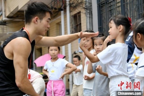 圖為大學(xué)生志愿者在組織孩子們參加體育健身活動(dòng)。廖光福 攝