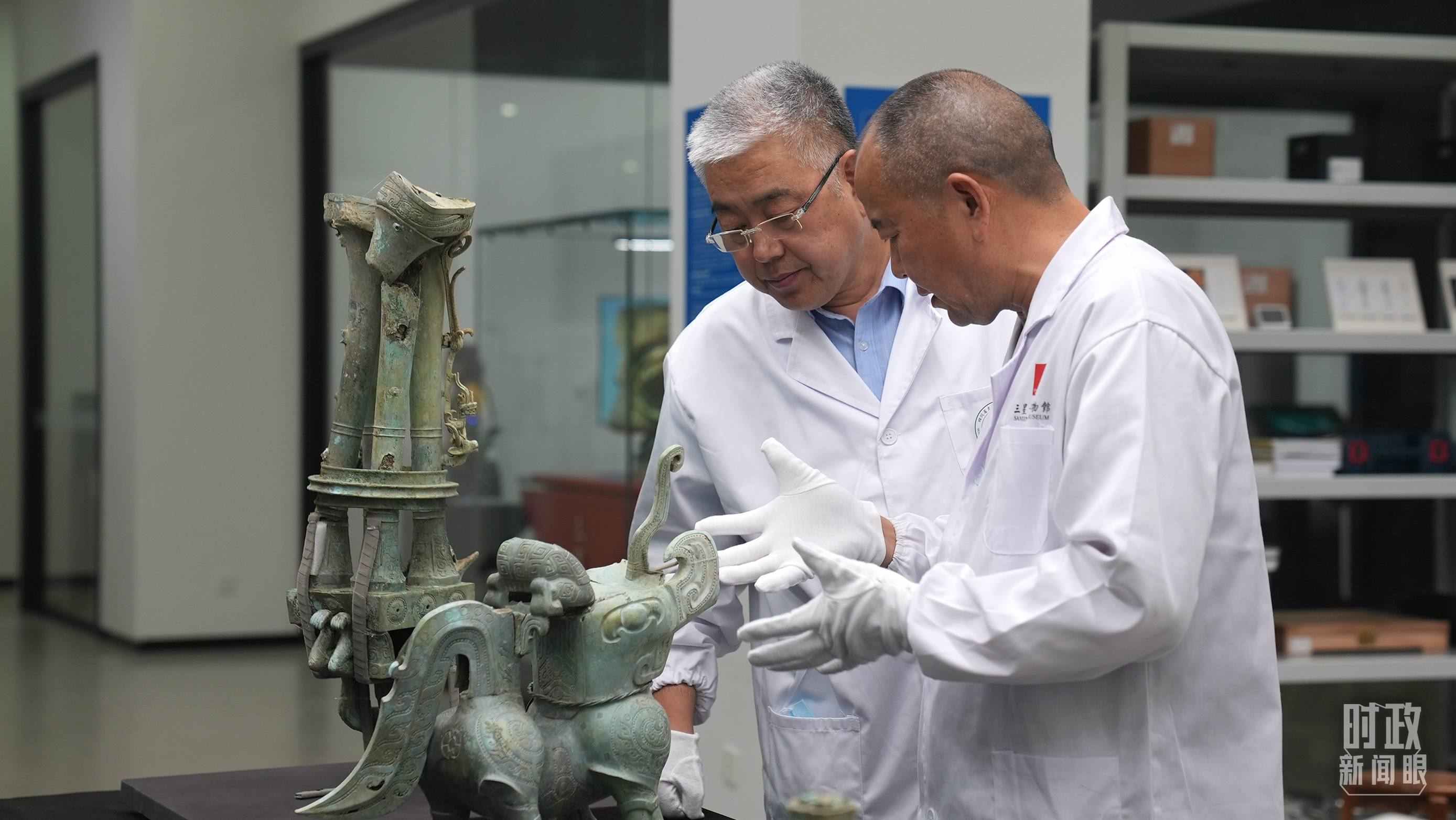 △三星堆文保專家正在就修復(fù)方案進(jìn)行討論。（總臺央視記者劉琦拍攝）