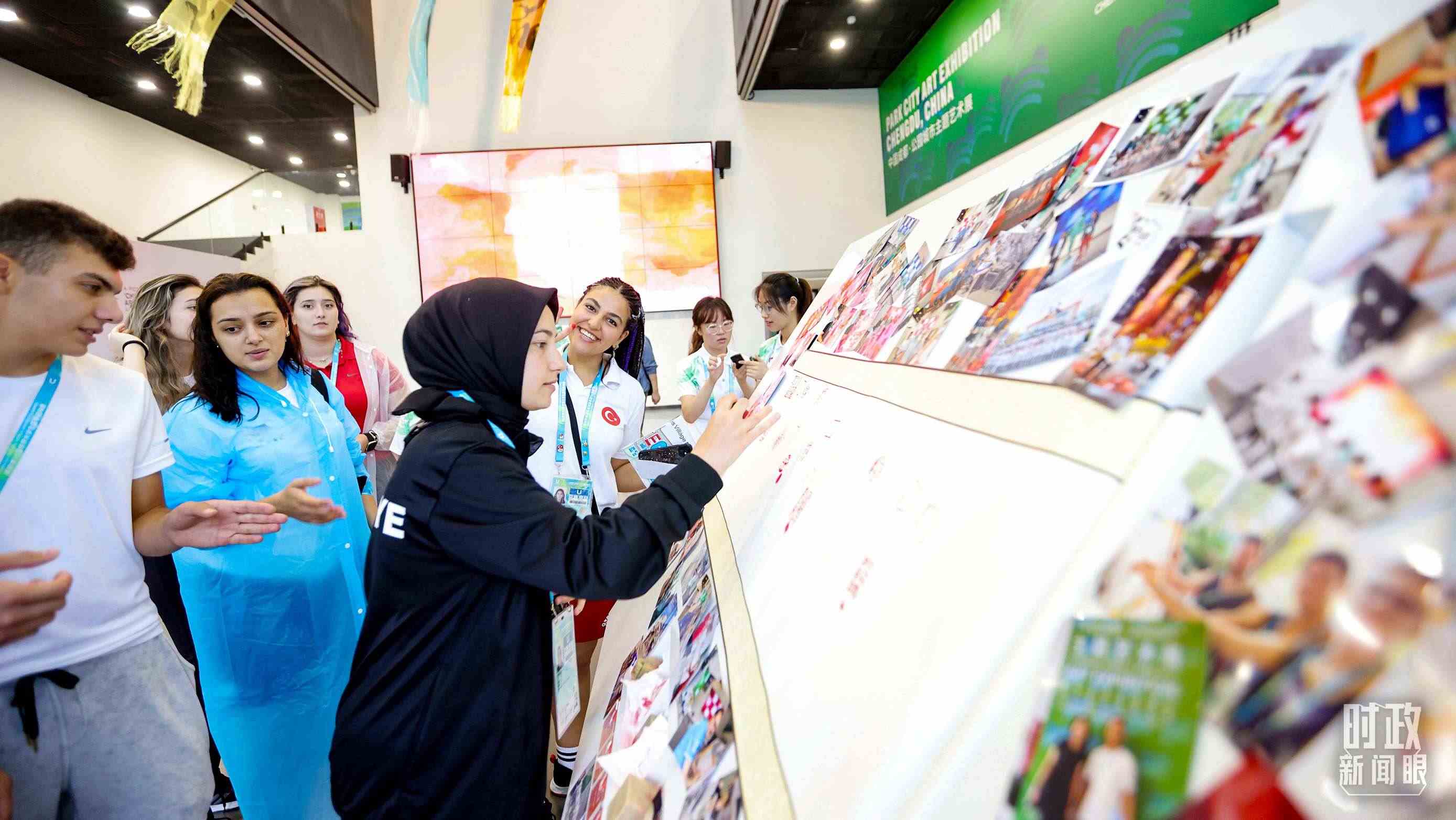 各國青年運動員正在參觀成都大運村內的“雪山下的公園城市，煙火里的幸福成都”主題藝術展。（總臺央視記者魏幫軍拍攝）