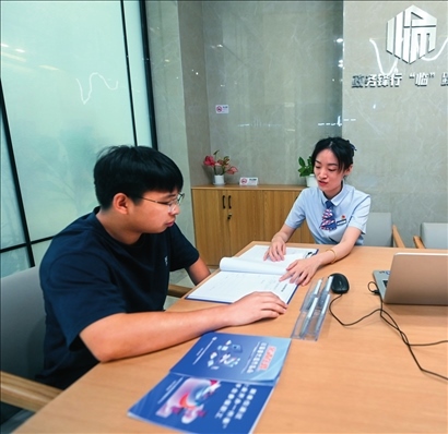 在杭州市臨安區(qū)政務(wù)服務(wù)中心的“為企服務(wù)中心”，黨員志愿者（右）解答企業(yè)主的疑問（2023年7月7日攝）。徐昱攝/本刊