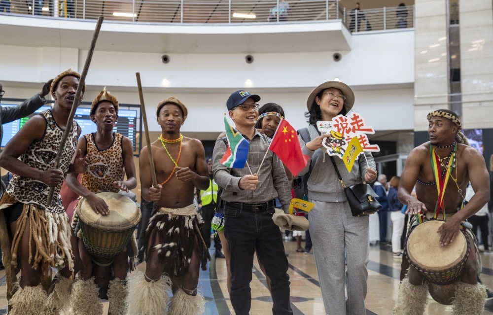 在南非約翰內(nèi)斯堡坦博國際機(jī)場(chǎng)，南非舞蹈演員歡迎中國試點(diǎn)恢復(fù)出境團(tuán)隊(duì)旅游后首批抵達(dá)南非的中國游客（2023年3月29日攝）。
