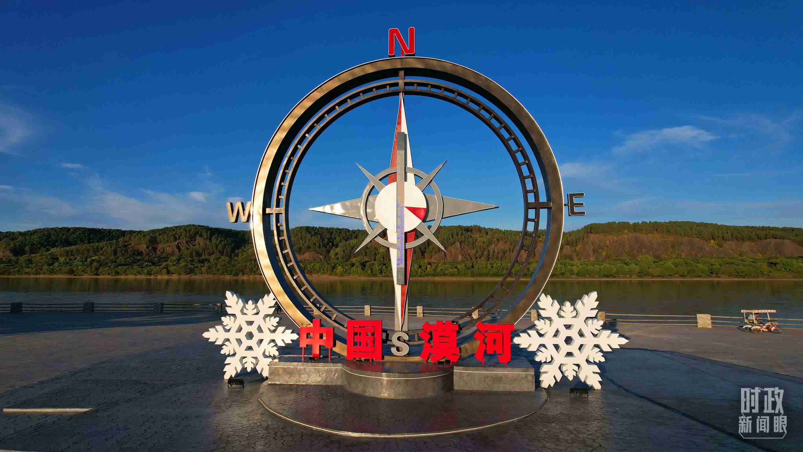 △指北針雕塑是北極村標志性建筑之一，其紅色指針指向正北方。上面的大型溫度計高12.22米，象征北極村位于東經(jīng)122°20′。（總臺央視記者范凱拍攝）