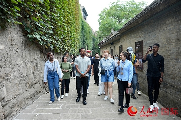 選手們認(rèn)真聆聽導(dǎo)游講解。人民網(wǎng) 盧鵬宇攝