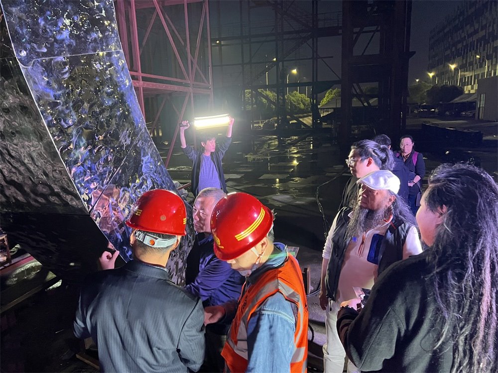 林崗（右二）和團(tuán)隊(duì)查看主火炬制作進(jìn)度。受訪者供圖