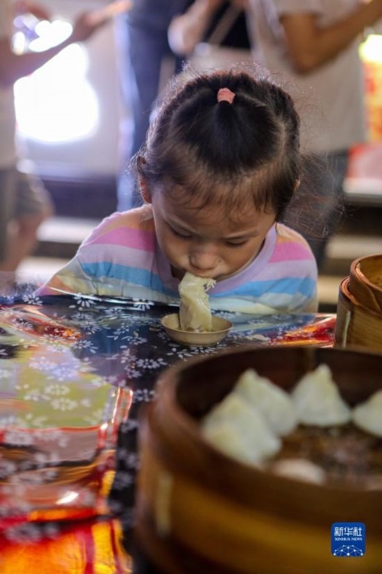 9月27日，小朋友在南翔小籠長(zhǎng)街宴上品嘗南翔小籠。