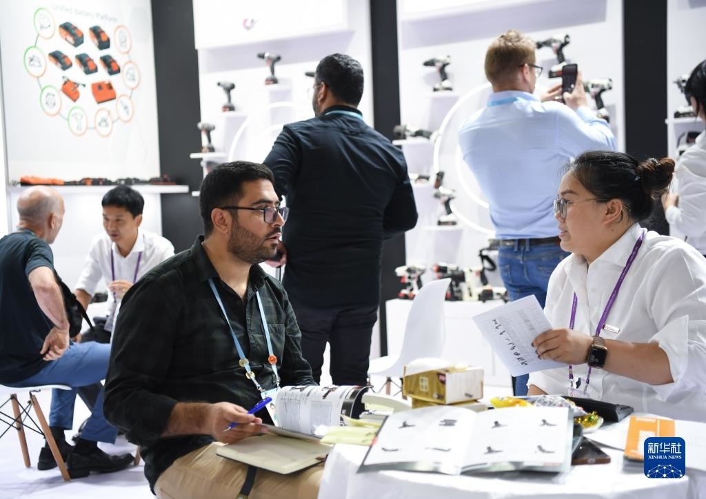 10月15日，在一家電動(dòng)工具展臺(tái)，外國采購商在洽談業(yè)務(wù)。新華社記者 鄧華 攝