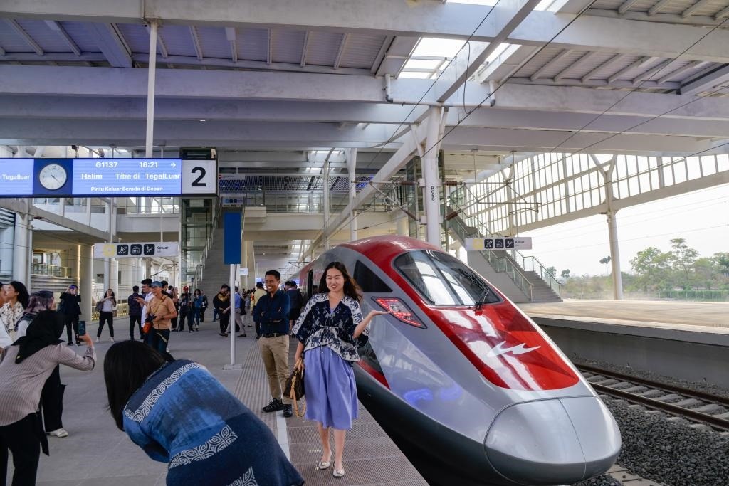 10月17日，在印度尼西亞萬(wàn)隆德卡魯爾站，乘客在站臺(tái)上和雅萬(wàn)高鐵高速動(dòng)車(chē)組列車(chē)合影。