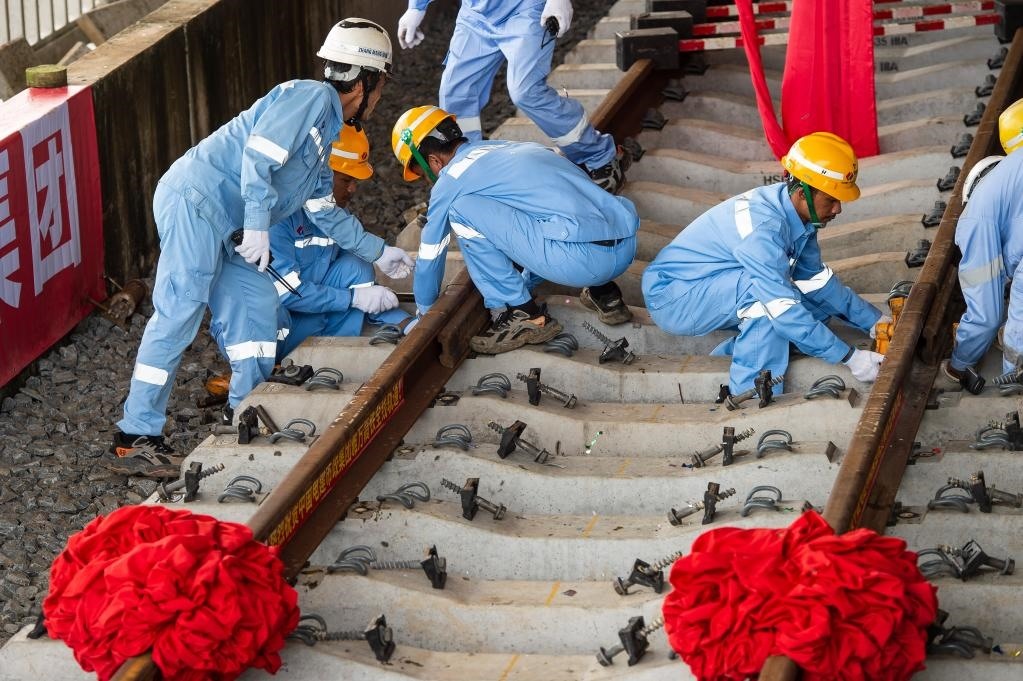 3月31日，在印度尼西亞雅加達(dá)雅萬(wàn)高鐵哈利姆車(chē)站，工人鋪設(shè)雅萬(wàn)高鐵全線最后一根鋼軌。