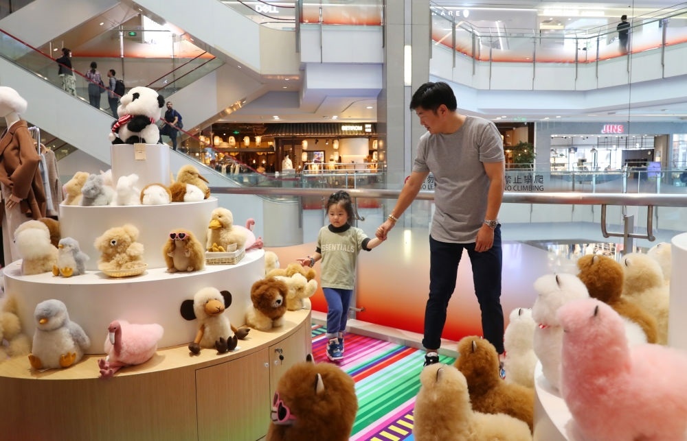 2023年11月2日，顧客在溫暖駝品牌專柜內(nèi)選購。連續(xù)六年參加進(jìn)博會的秘魯羊駝制品品牌溫暖駝在上海市中心商場開設(shè)了專柜。新華社記者 方喆 攝