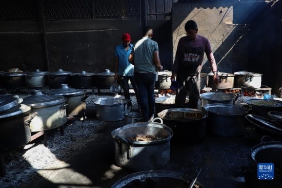 11月3日，在加沙地帶南部城市拉法，人們?cè)诿簹庵袛嗪笥貌窕鹱鲲?。新華社發(fā)（里澤克·阿卜杜勒賈瓦德攝）