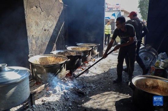 11月3日，在加沙地帶南部城市拉法，人們?cè)诿簹庵袛嗪笥貌窕鹱鲲?。新華社發(fā)（里澤克·阿卜杜勒賈瓦德攝）