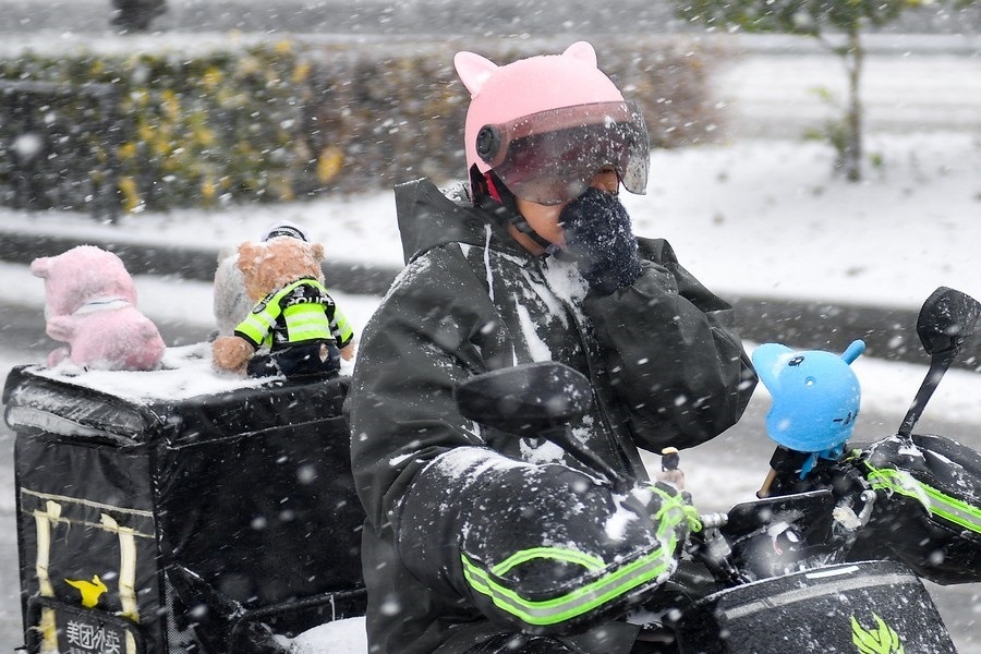 11月6日，在長(zhǎng)春市街頭，一名外賣員在雪中騎行。新華社記者 許暢 攝