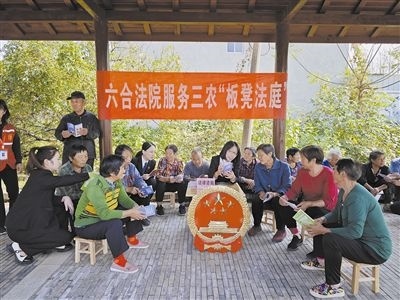  圖③：干警向附近農(nóng)戶解讀相關(guān)法律法規(guī)。