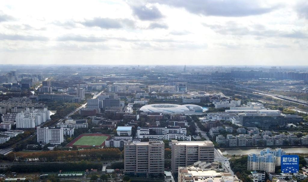 這是2023年11月25日在上海浦東新區(qū)張江科學城拍攝的形如鸚鵡螺的大科學裝置上海光源（中）（無人機照片）。新華社記者 方喆 攝