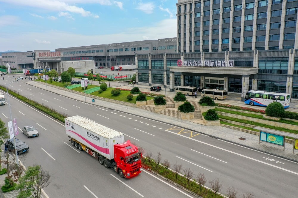 2023年10月11日，滿載筆記本電腦配件、發(fā)電機(jī)組件等產(chǎn)品的西部陸海新通道跨境公路班車從重慶南彭公路保稅物流中心駛出，將途經(jīng)廣西憑祥，直達(dá)越南（無人機(jī)照片）。新華社記者 黃偉 攝