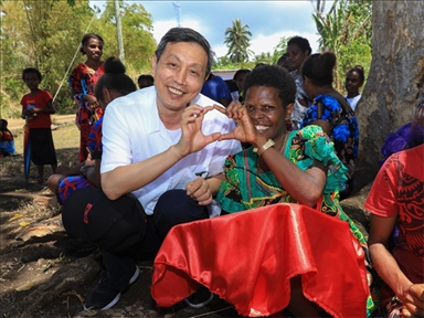 2023年12月18日，中國駐瓦努阿圖大使李名剛和前來觀看瓦努阿圖公路項目二期馬勒庫拉段移交儀式的當地居民合影。人民網 賀吉攝