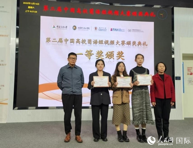 澳門大學(xué)中葡雙語教學(xué)暨培訓(xùn)中心主任姚京明（左一）和中國傳媒大學(xué)外國語言文化學(xué)院院長文春英（右一）為一等獎(jiǎng)獲得者頒獎(jiǎng)。人民網(wǎng)記者 魯揚(yáng)攝