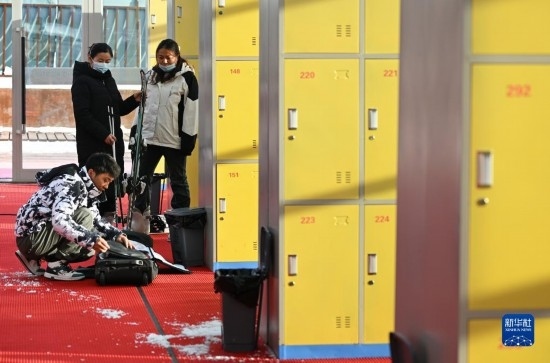 12月21日，游客在滑雪服務(wù)大廳整理滑雪裝備。