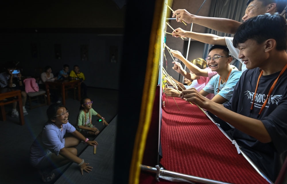 2023年8月8日，進行暑期研學(xué)的學(xué)生在位于陜西省西安市的中國秦腔藝術(shù)博物館體驗皮影戲演出。新華社記者 鄒競一 攝