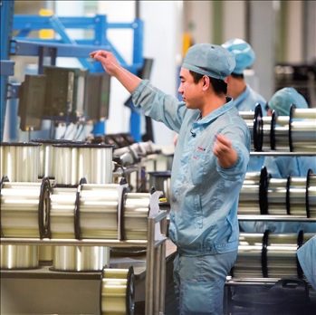 在位于武漢的長飛光纖光纜股份有限公司光纖生產(chǎn)車間內(nèi)，工作人員對光纖進行檢測（資料圖片）。肖藝九攝/本刊