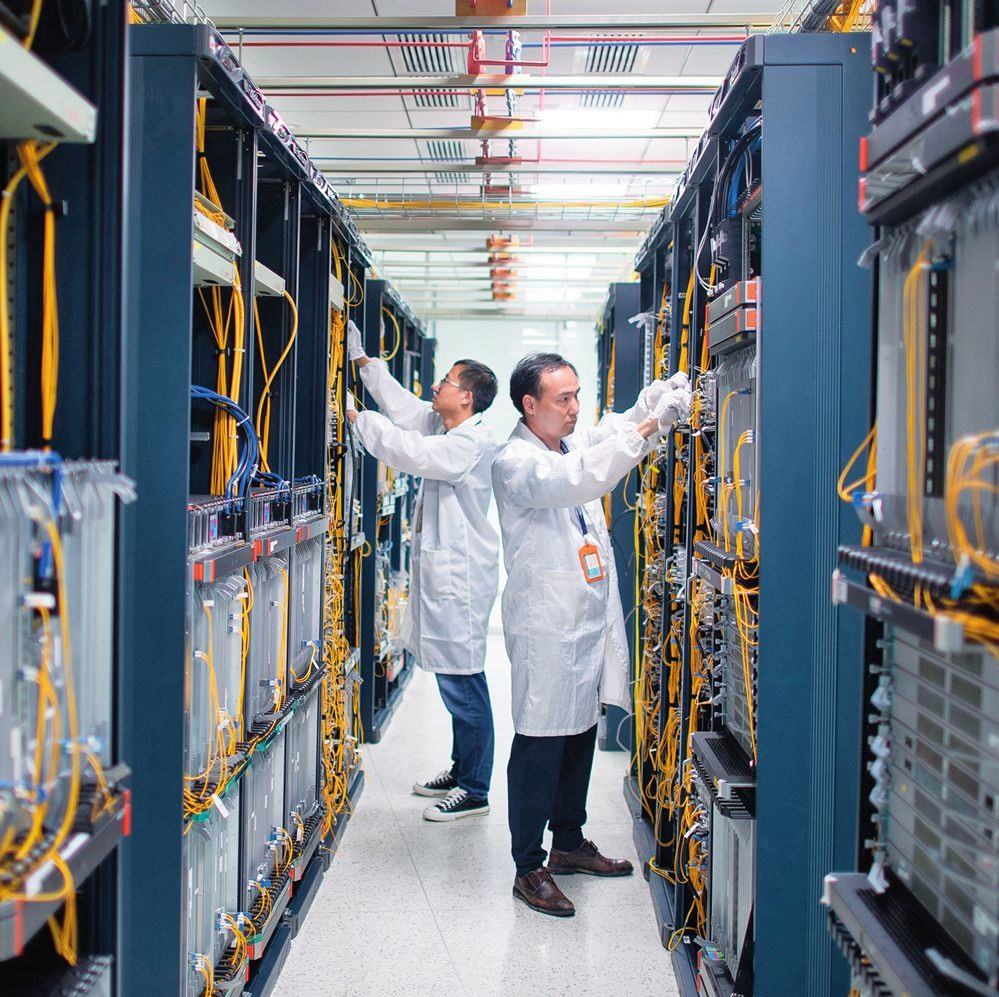 在位于武漢中國光谷的光電器件研發(fā)制造商——武漢光迅科技股份有限公司生產(chǎn)車間內(nèi)，技術人員在光模塊生產(chǎn)線作業(yè)（2023年4月11日攝）。程敏攝/本刊