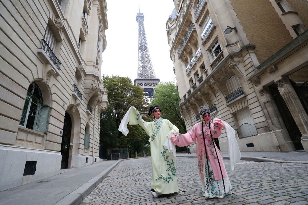 2023年9月13日，江蘇省演藝集團(tuán)昆劇院院長施夏明（左）和江蘇省演藝集團(tuán)昆劇院國家一級演員孔愛萍在法國巴黎埃菲爾鐵塔附近參加昆曲快閃。新華社記者 高靜 攝