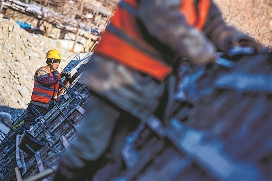 1月3日，房山區(qū)，工人正在雙泉河修筑堤壩。