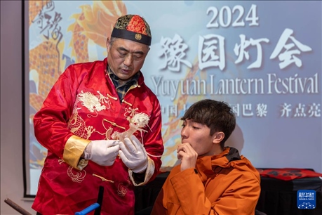 1月28日，在上海豫園舉行的民俗活動上，美國馬斯卡廷中學學生在非遺傳承人的指導(dǎo)下吹糖偶。 新華社記者 王翔 攝