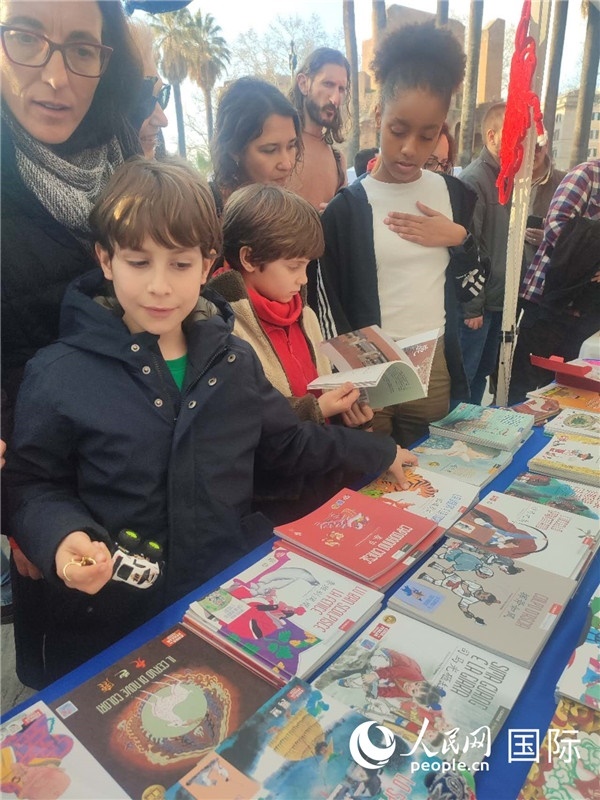 印刷精美的中國傳統(tǒng)文化叢書吸引了小游客的注意。人民網(wǎng)記者鄭彬攝