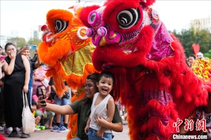 圖為舞獅表演吸引民眾合影。張興龍攝