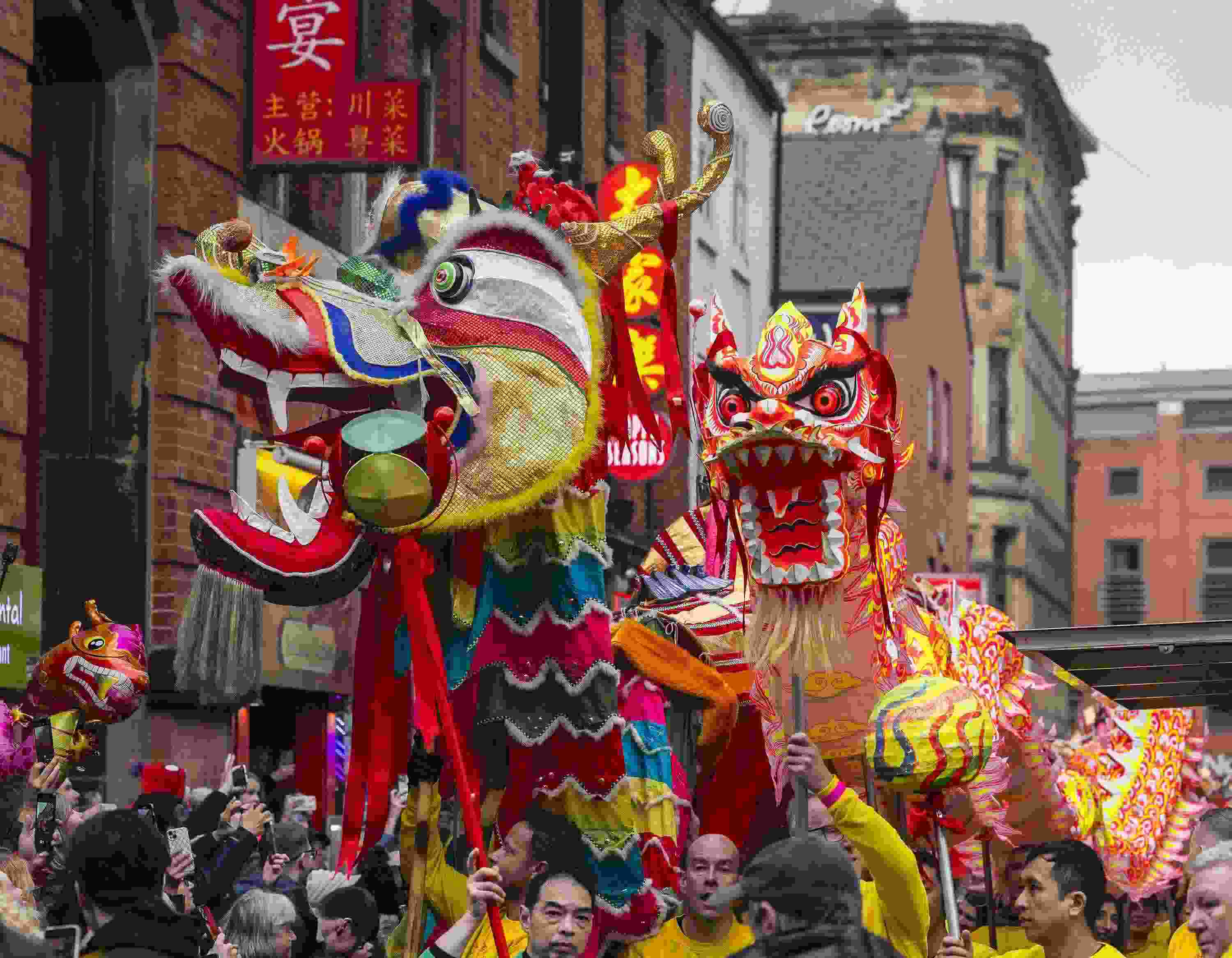 △ 當?shù)貢r間2024年2月11日，英國曼徹斯特，表演者進入中國城，參加中國農(nóng)歷龍年春節(jié)的慶?；顒印? width=