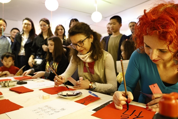 羅馬尼亞觀眾學(xué)習(xí)用毛筆寫“?！弊帧Ｖ袊幕行墓﹫D