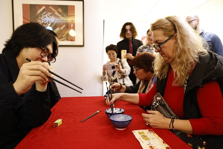 羅馬尼亞觀眾體驗(yàn)用筷子夾花生。中國文化中心供圖