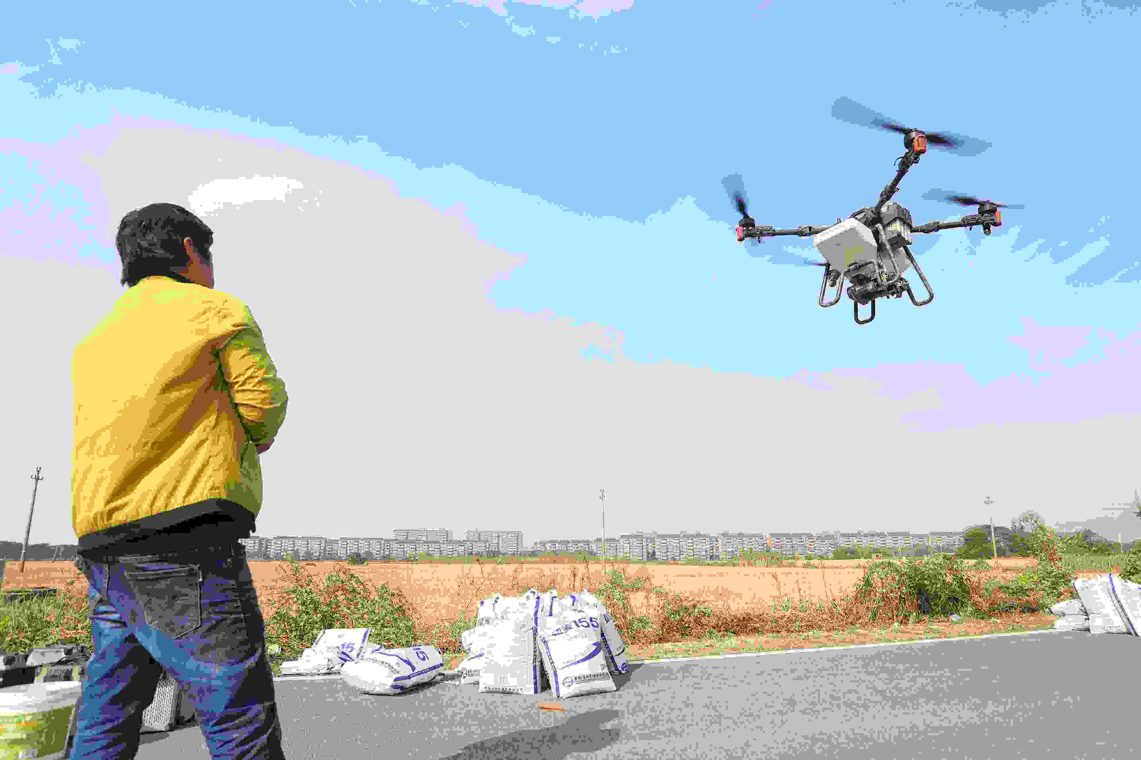 2023年11月15日，浙江嘉興，南湖區(qū)七星街道一處農(nóng)田里，農(nóng)民操縱無人機(jī)進(jìn)行冬小麥飛播。