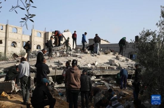  3月3日，在加沙地帶南部城市拉法，人們查看被以軍空襲破壞的建筑。新華社發(fā)（哈立德·奧馬爾攝）