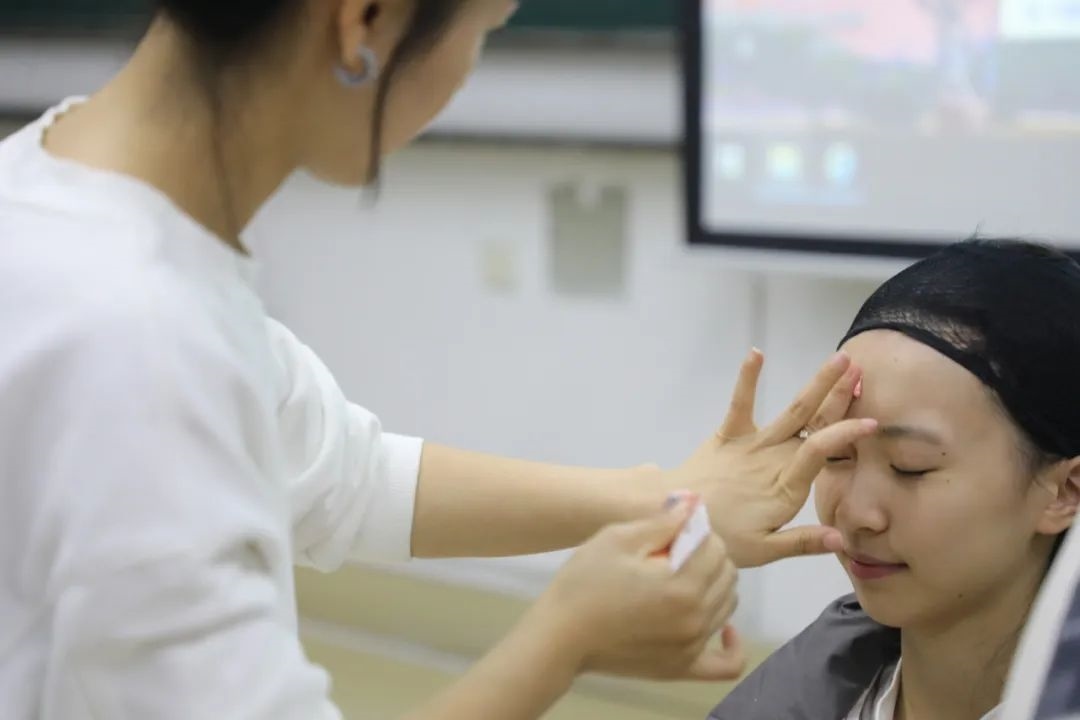 課堂上，一名學生在體驗上戲妝。學校供圖