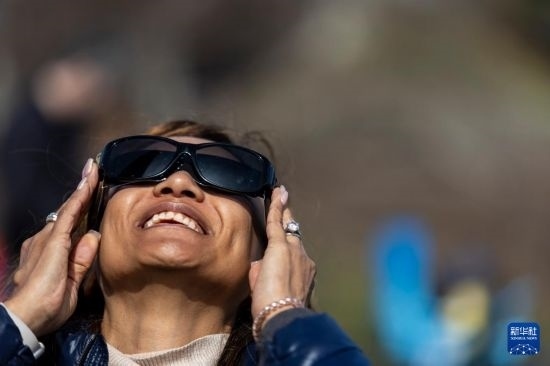 4月8日，一名女子在美國(guó)紐約州普拉茨堡觀看日食。新華社發(fā)（文森特·約翰遜攝）