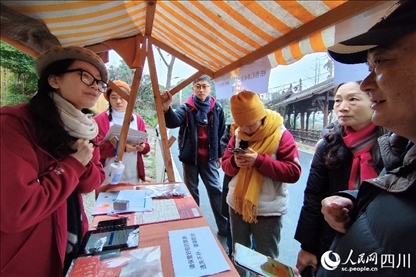 1月6日，“2024成都蒲江柑甜采摘節(jié)”上，記者見到了小萌（左一）和許多年輕人忙著做訪客接待、現(xiàn)場布置、票務(wù)核對、采摘服務(wù)等工作。人民網(wǎng)記者朱虹攝