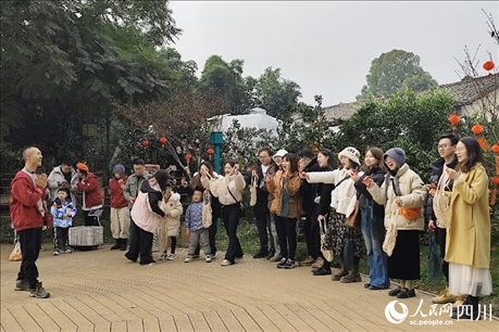 葉科（左一）給前來參與活動的“柑爸柑媽”介紹生態(tài)種植果。人民網(wǎng)記者朱虹攝