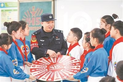 圖為公安民警給學(xué)生們講解國(guó)家安全知識(shí)。張鷹攝