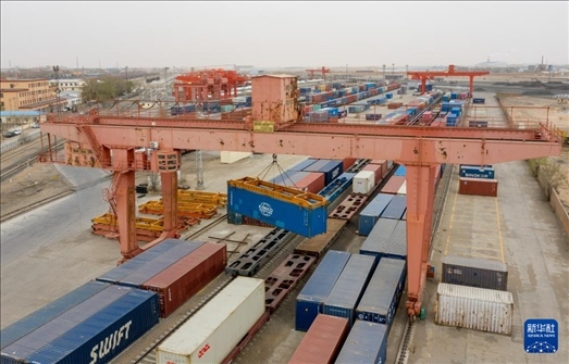 4月21日，二連浩特鐵路口岸龍門吊吊裝中歐班列集裝箱（無(wú)人機(jī)照片）。 新華社發(fā)（張海峰攝）