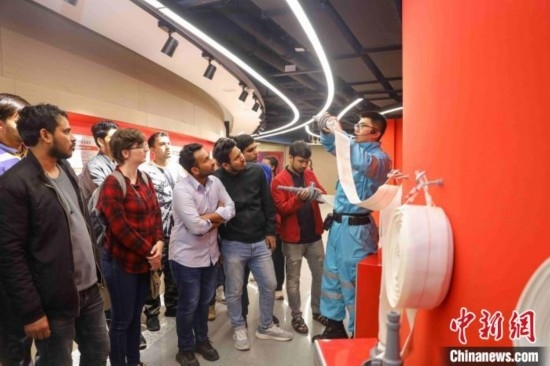 5月9日，工作人員指導(dǎo)留學(xué)生正確使用消防水帶。張鷹 攝