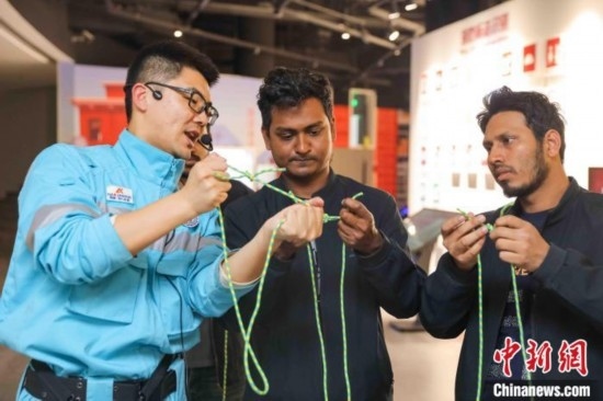 5月9日，工作人員指導(dǎo)留學(xué)生學(xué)習(xí)打繩結(jié)。張鷹 攝